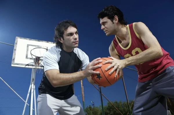 Unga män som spelar basket — Stockfoto