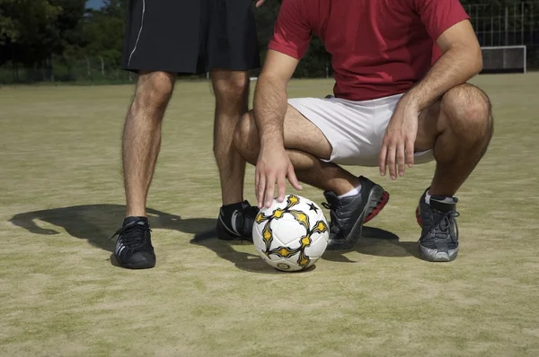 Pernas masculinas com bola de futebol — Fotografia de Stock