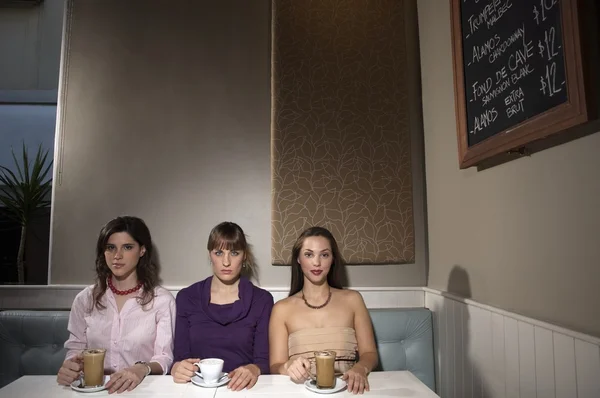 Mulheres jovens sentadas à mesa no restaurante — Fotografia de Stock