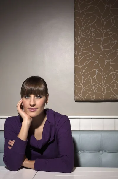 Jeune femme assise à table — Photo