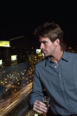 Balkonda duran yakışıklı genç