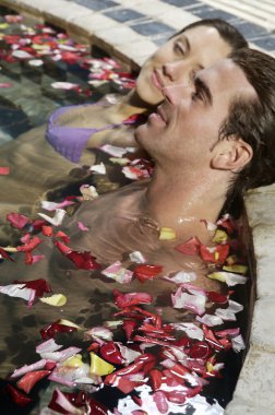 Genç çift yüzme havuzunda dinleniyor.