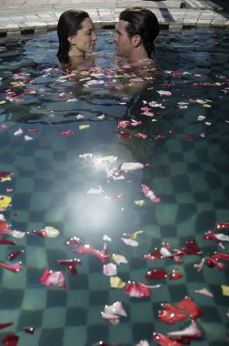 Genç çift yüzme havuzunda dinleniyor.