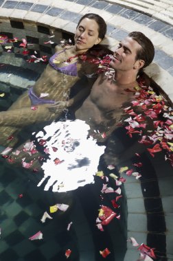 Genç çift yüzme havuzunda dinleniyor.