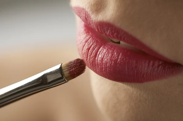 Vrouw die rode lippenstift aanbrengt — Stockfoto