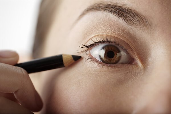 woman having eyeliner applied