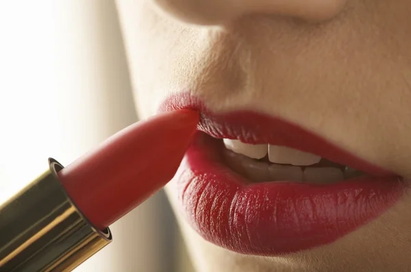 Mujer aplicando lápiz labial rojo — Foto de Stock