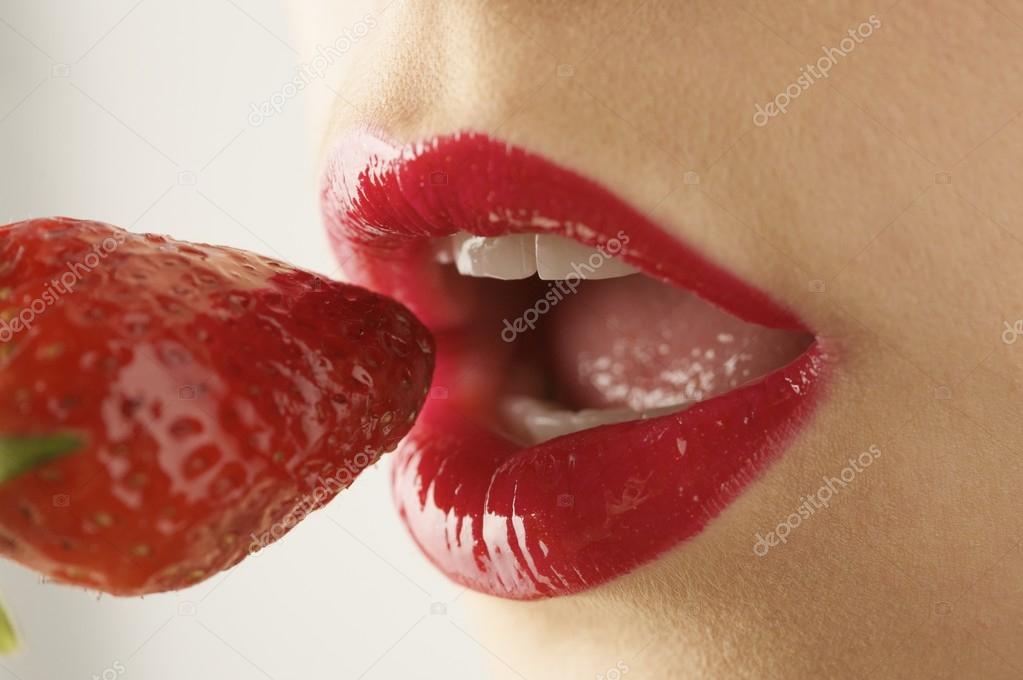 female mouth eating strawberry