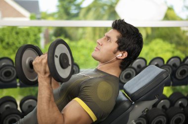 Dambıllarla egzersiz yapan adam.