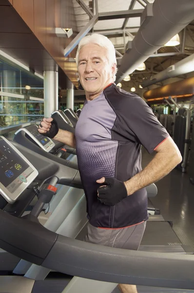 Hombre mayor haciendo ejercicio en la cinta de correr — Foto de Stock