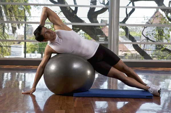 Hombre haciendo ejercicio con una pelota de gimnasio — Foto de Stock