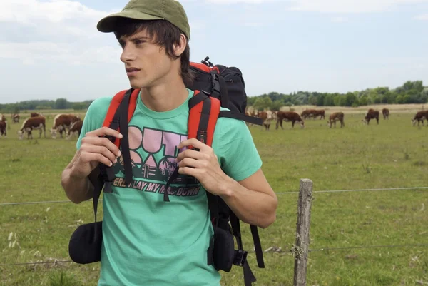 Joven con mochila en el prado —  Fotos de Stock