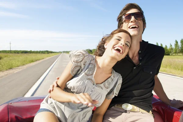 young couple sitting in back seat