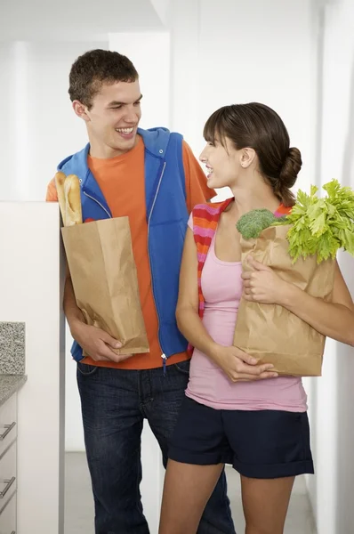 Jeune couple apportant épicerie à la cuisine — Photo