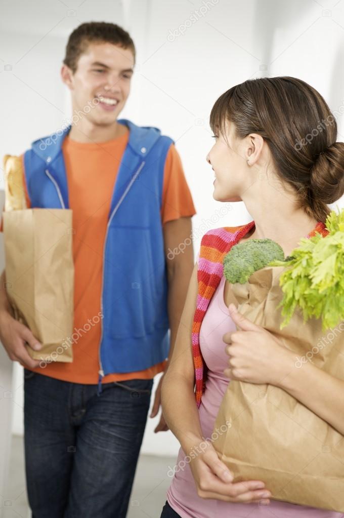 young couple carrying groceries