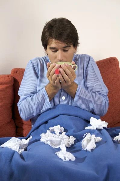 Hombre enfermo con pañuelos bebiendo té — Foto de Stock