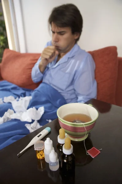 Malade tousse et s'assoit sur le canapé — Photo