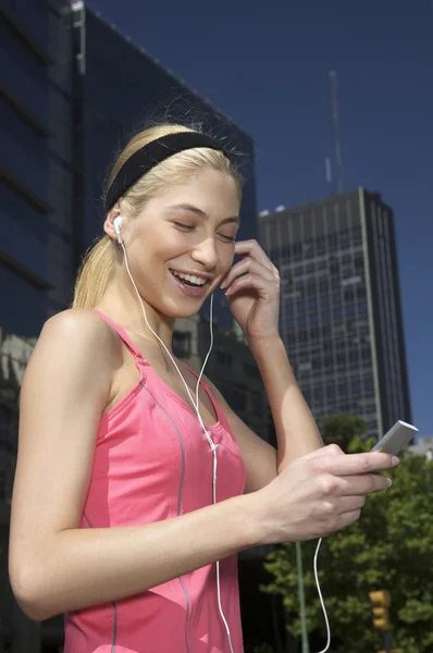 Kvinna som lyssnar på en mp3-spelare — Stockfoto