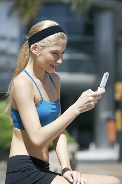 Femme regardant un téléphone portable — Photo