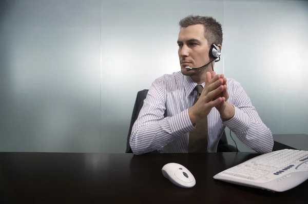 Empresário falando através de fone de ouvido telefone — Fotografia de Stock