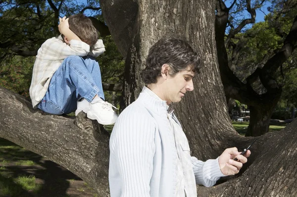 Маленький мальчик сидит на дереве — стоковое фото