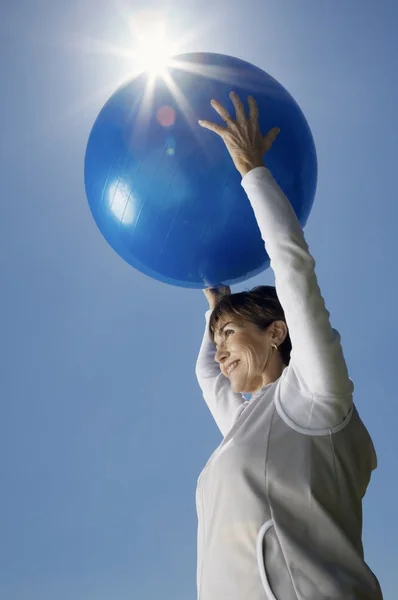 Uma mulher idosa segurando uma bola de exercício — Fotografia de Stock