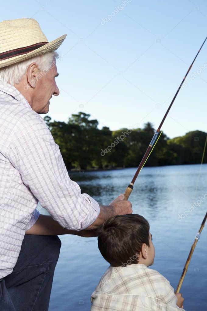 boy and his grandfather with fishing rods