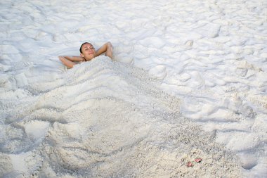 Girl lying on white sand clipart