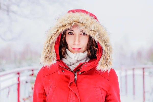 Девушка в красном пальто с капюшоном гуляет по парку — стоковое фото