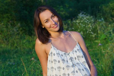 hamile kız çimlerin üzerinde oturuyor.