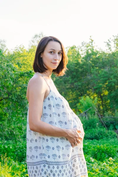 Беременная девушка в сарафане Стоковое Изображение