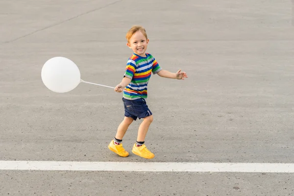 Мальчик бежит с воздушным шаром — стоковое фото