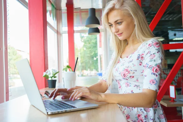 Девушка, работающая за ноутбуком в кафе Лицензионные Стоковые Фото