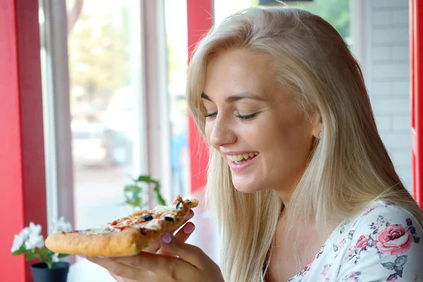 Девушка смеется и ест пиццу . Стоковая Картинка