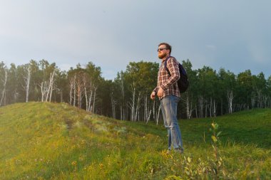 Adam bir tepe ve gün batımını izlemek duruyor.