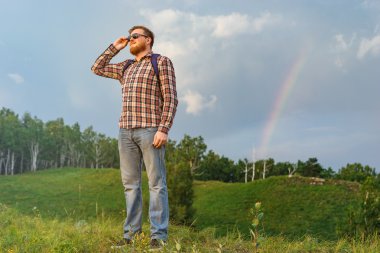 Adam bir tepe ve gün batımını izlemek duruyor.