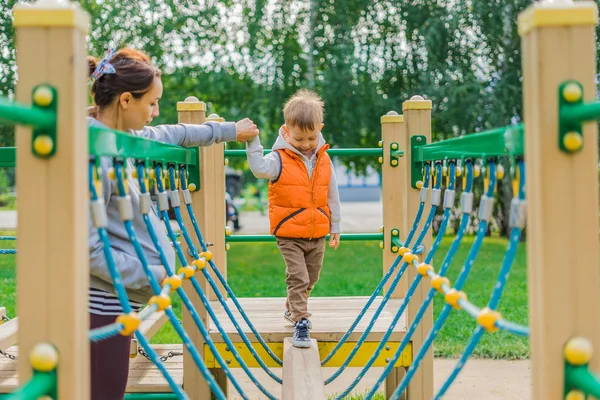 Мальчик ходит по полю на детской площадке — стоковое фото