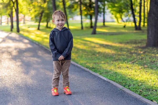 Jongen staat in het steegje in het park. — Stockfoto