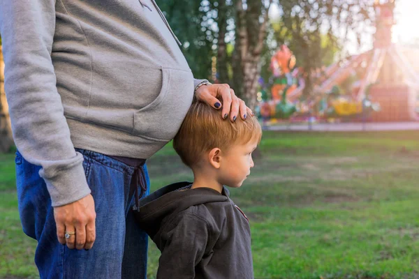 Zwangere moeder en haar zoon in het park, — Stockfoto