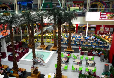 Palmiye ağaçlarının hakim olduğu büyük alışveriş merkezindeki kafe. Yemek katı. Bistro 'da bir sürü masa var. - Rusya. Krasnoyarsk. 31 Aralık 2008