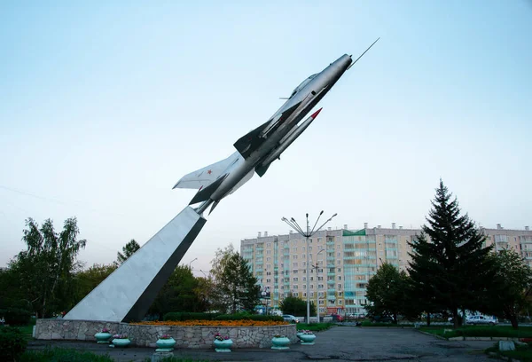 model of an old Soviet fighter plane in  form of  monument in a square on  background of residential buildings. Russia. Krasnoyarsk. September 11, 2015