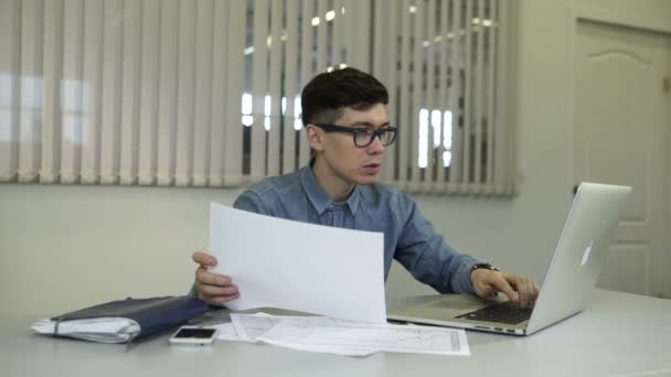 Casual jovem trabalhando no escritório, sentado na mesa, digitando no teclado — Vídeo de Stock