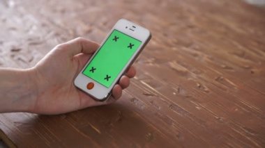 Akıllı telefon üzerinde ahşap masa kullanarak çeşitli el jestleri, dikey