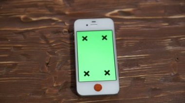 Ahşap masa yeşil ekran akıllı telefon