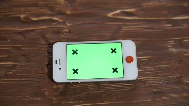 Teléfono inteligente de pantalla verde en la mesa de madera . — Vídeos de Stock