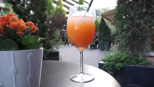 Женщина наслаждается стаканом апельсинового коктейля в городе — стоковое видео