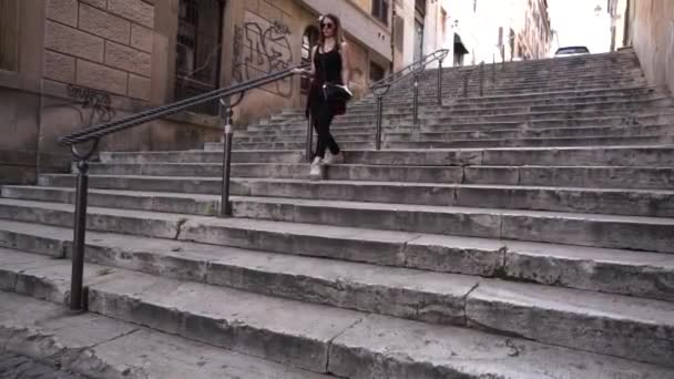 Mladá bruneta žena chůze po schodech. — Stock video