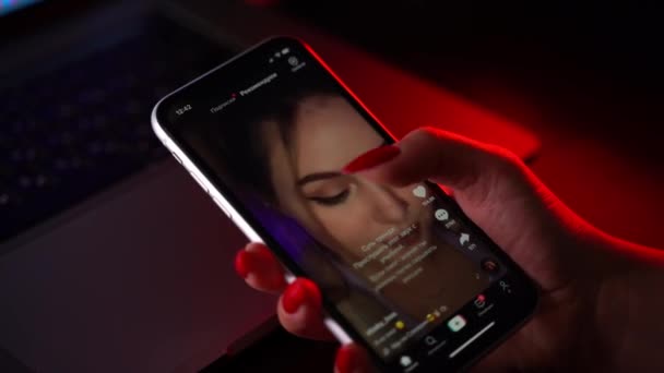 MOSCOW, RUSSIA, 20 EKİM 2020. Kırmızı manikürlü kadın eli iPhone 'u canlı yayın yapan servis medyası ve ekranda video TikTok ile tutuyor.. — Stok video