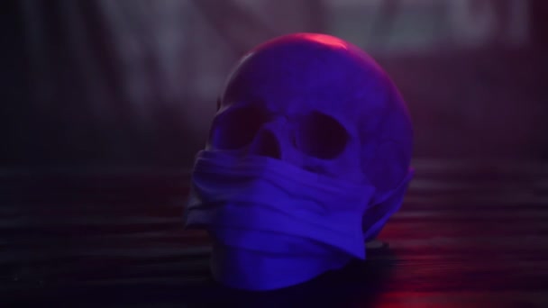 头盖骨头戴蓝色口罩，头戴黑色背景的头盖骨概念 — 图库视频影像