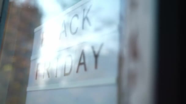 Lightbox Sign Viernes Negro detrás de una puerta de cristal de la cafetería. Concepto Viernes Negro, temporada de ventas. — Vídeos de Stock